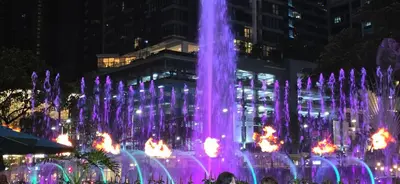 a fountain with purple lights in front of a building at Explore Mitsukoshi Uptown BGC, large TV, fast WIFI in Manila