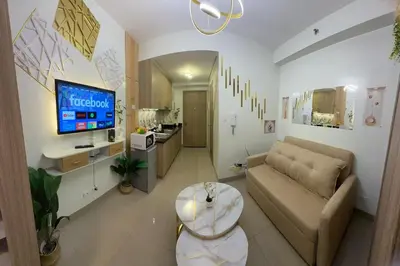 a living room with a couch and a tv at Shore 2 Residences Tower 3 by HappyHaven in Manila
