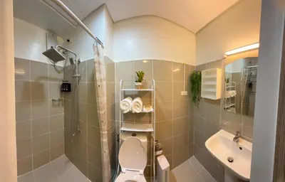 a bathroom with a shower and a toilet and a sink at Shore 2 Residences Tower 3 by HappyHaven in Manila