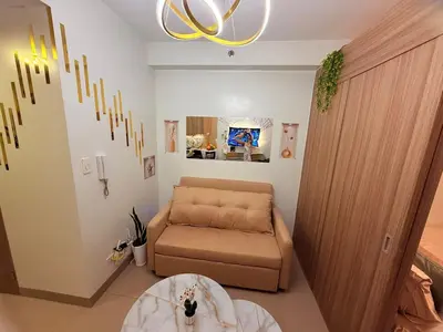 a living room with a couch and a table at Shore 2 Residences Tower 3 by HappyHaven in Manila