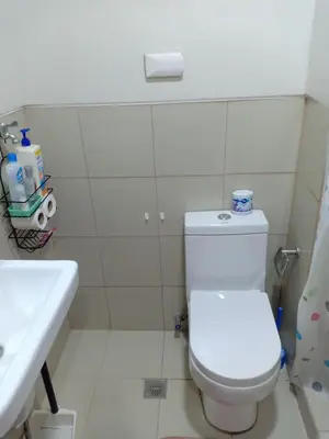 a bathroom with a white toilet and a sink at Jade Loft in Manila