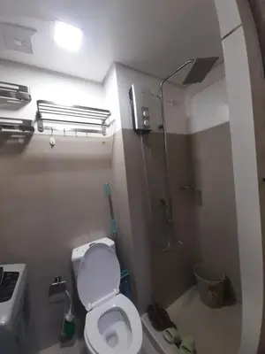 a small bathroom with a toilet and a shower at Shore Residences Tower B near MOA and IKEA Pasay City in Manila