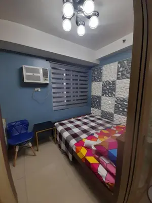 a bedroom with a bed and a table and a fan at Shore Residences Tower B near MOA and IKEA Pasay City in Manila