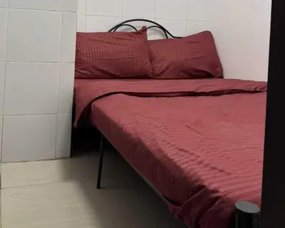 a bed with red sheets and pillows in a room at OYO 1155 Carnivale Inn in Manila