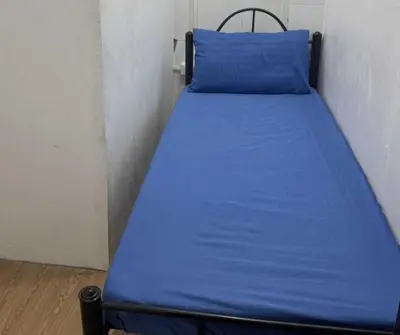 a bed in a small room with a blue blanket at OYO 1155 Carnivale Inn in Manila