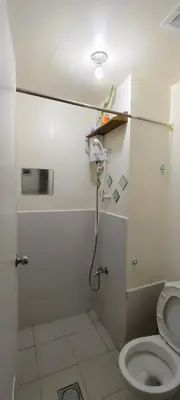 a white bathroom with a toilet and a light at JJMC PLACE 28 With Netflix and Unli Wifi in Manila