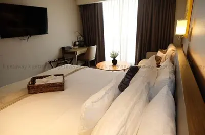 a bedroom with a large white bed with a flat screen tv at Acqua at The Hotel Residences Acqua Manila near Makati and BGC in Manila
