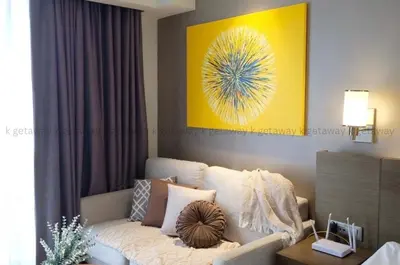 a living room with a couch and a yellow painting at Acqua at The Hotel Residences Acqua Manila near Makati and BGC in Manila