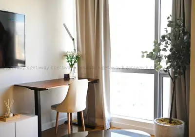a desk and a chair in a room with a window at Acqua at The Hotel Residences Acqua Manila near Makati and BGC in Manila