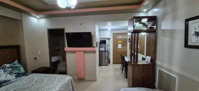 a room with a bedroom with a bed and a television at Rqui Condotel Newport Pasay City in Manila