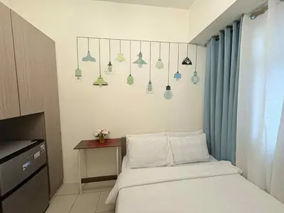 a bedroom with a bed and a table and some lights at JJMC HOMESTAY 29 with Netflix and Wifi in Manila