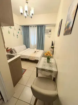 a bedroom with a bed and a table and a sink at JJMC HOMESTAY 29 with Netflix and Wifi in Manila