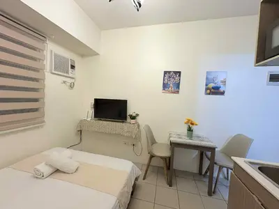 a small room with a bed and a table with a television at JJMC PLACE 29 With Netflix and Unli Wifi in Manila