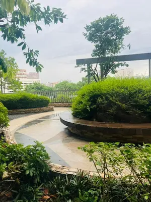 a park with a fountain and a bench and bushes at Astra Heights Staycation in Manila