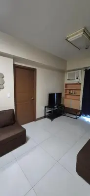 a living room with a couch and a television at Rqui Condotel Pasay City Manila in Manila