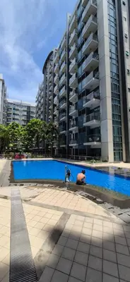 a swimming pool in front of a tall building at Rqui Condotel Pasay City Manila in Manila