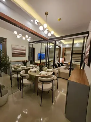 a living room with tables and chairs and a couch at Luxury apartment at Bloom Residences in Manila