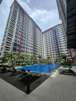 a large apartment building with a large swimming pool at Luxury apartment at Bloom Residences in Manila