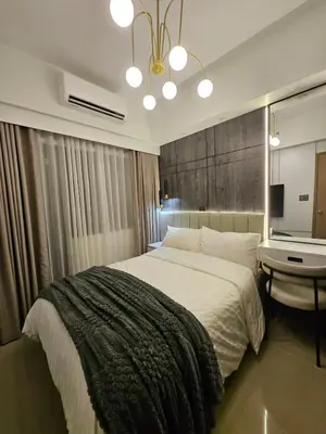 a bedroom with a large bed and a desk at Luxury apartment at Bloom Residences in Manila