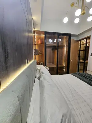 a bedroom with a large bed with white sheets at Luxury apartment at Bloom Residences in Manila