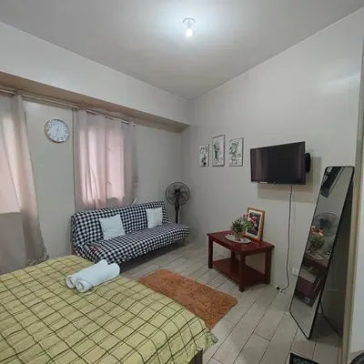 a living room with a bed and a couch at Rose 150newport pasay in Manila