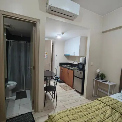 a small room with a bed and a kitchen at Rose 150newport pasay in Manila