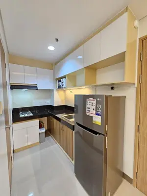 a kitchen with a stainless steel refrigerator and wooden cabinets at In My Jib Sucat in Manila