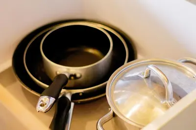 a pot and a pan on top of a counter at Spacious Condo with 50in TV & Netflix, Near Malls in Manila