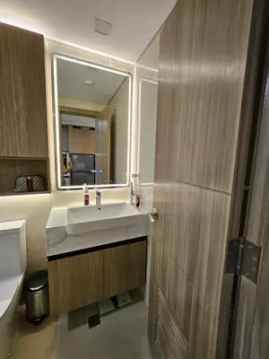a bathroom with a sink and a mirror at Luxury apartment at Park McKinley West suite 1 in Manila