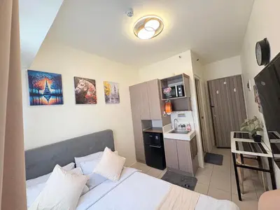 a small bedroom with a bed and a kitchen at JJMC HOMESTAY 28 With Netflix and Unli Wifi in Manila