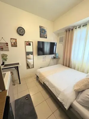 a bedroom with a bed and a flat screen tv at JJMC HOMESTAY 28 With Netflix and Unli Wifi in Manila