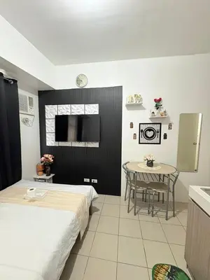a room with two beds and a table in it at JJMC PLACE 6 With Netflix and Unli Wifi in Manila