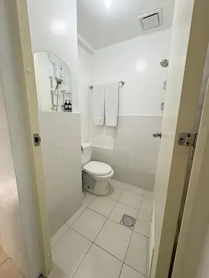 a white bathroom with a toilet and a mirror at JJMC PLACE 6 With Netflix and Unli Wifi in Manila