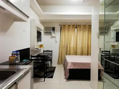 a small room with a bed and a kitchen at Grand Riviera Condotel Near St lukes Medical Center in Manila