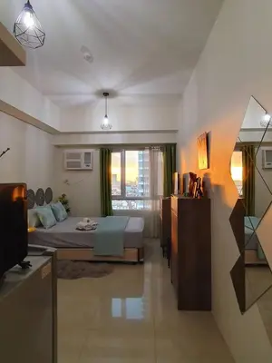 a hotel room with a bed and a window at Zeke Suite At Beacon Tower Amorsolo unit 2330 in Manila