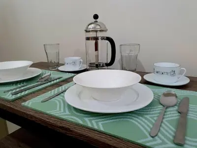 a table with plates and cups and a tea kettle at Zeke Suite At Beacon Tower Amorsolo unit 2330 in Manila