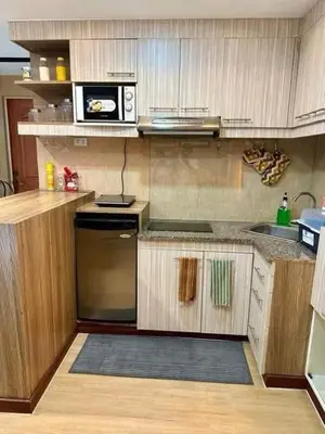 a kitchen with a stove and a microwave at Staycation at Starmall in Manila