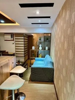 a bedroom with a blue bed and two tables and chairs at Staycation at Starmall in Manila