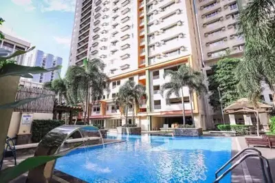 a large swimming pool in front of a building at Staycation at Starmall in Manila