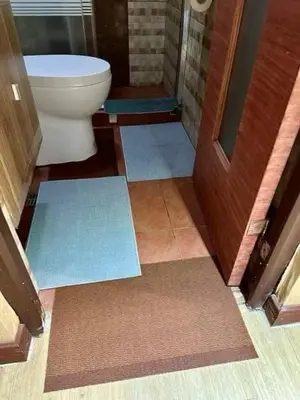 a bathroom with a toilet and mats on the floor at Staycation at Starmall in Manila
