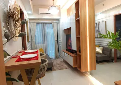 a living room with a table and a living room with a couch at F&M Deluxe Holiday Suite MOA SHORE 3 Residences