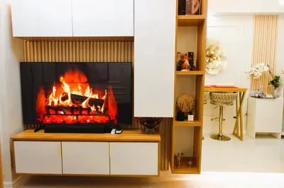 a fireplace in a living room with a fire at F&M Deluxe Holiday Suite MOA SHORE 3 Residences