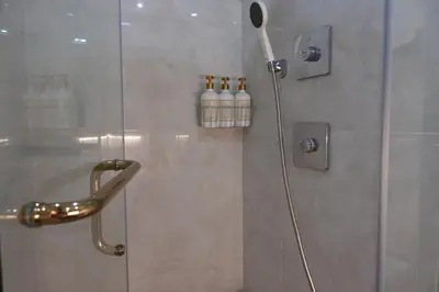a shower with a glass door with a shower head at F&M Deluxe Holiday Suite MOA SHORE 3 Residences