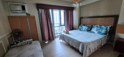 a bedroom with a bed and a large window at Condotel in Pasay City Manila in Manila