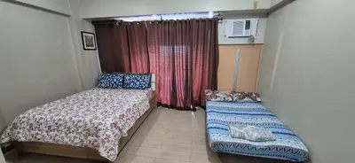 a small bedroom with a bed and a window at Condotel in Pasay City Manila in Manila
