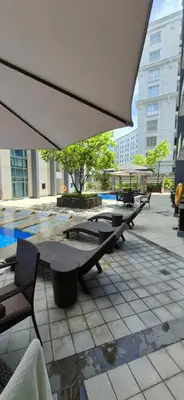 a group of tables and chairs under an umbrella at Condotel in Pasay City Manila in Manila