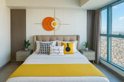 a bedroom with a bed with a yellow blanket at Luxury & Modern 2BR Penthouse in BGC in Manila