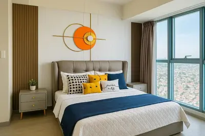 a bedroom with a large bed with yellow pillows at Luxury & Modern 2BR Penthouse in BGC in Manila