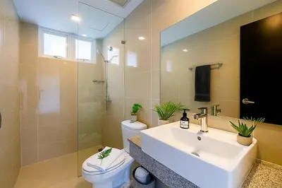 a bathroom with a sink and a toilet and a mirror at Luxury & Modern 2BR Penthouse in BGC in Manila