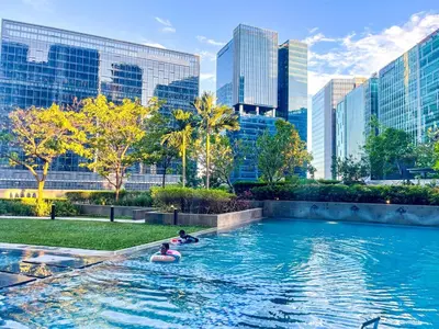 people floating in a pool in a city with tall buildings at Luxury & Modern 2BR Penthouse in BGC in Manila